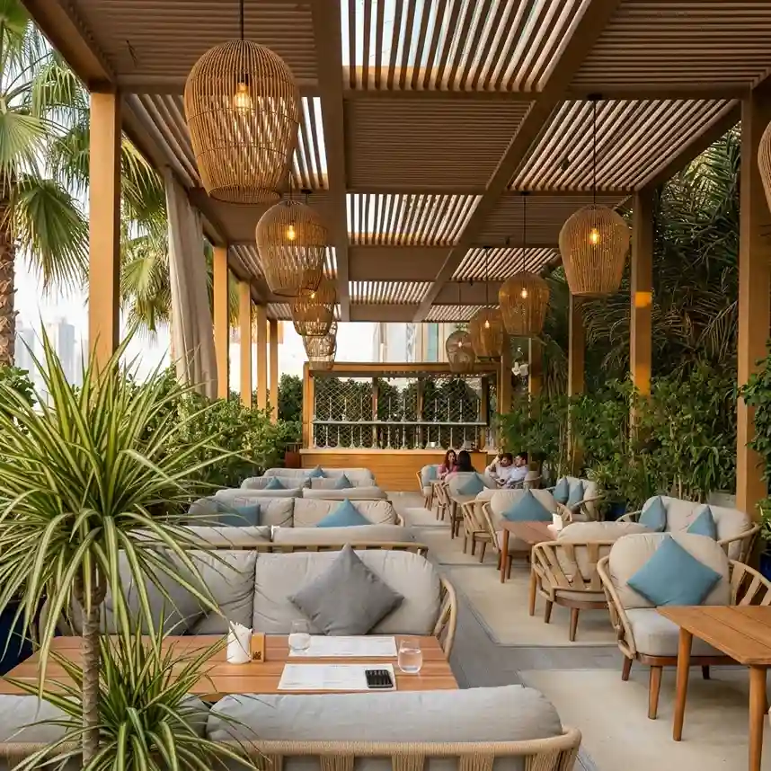 Hotel restaurant patio with outdoor seating and hanging lights under a covered terrace