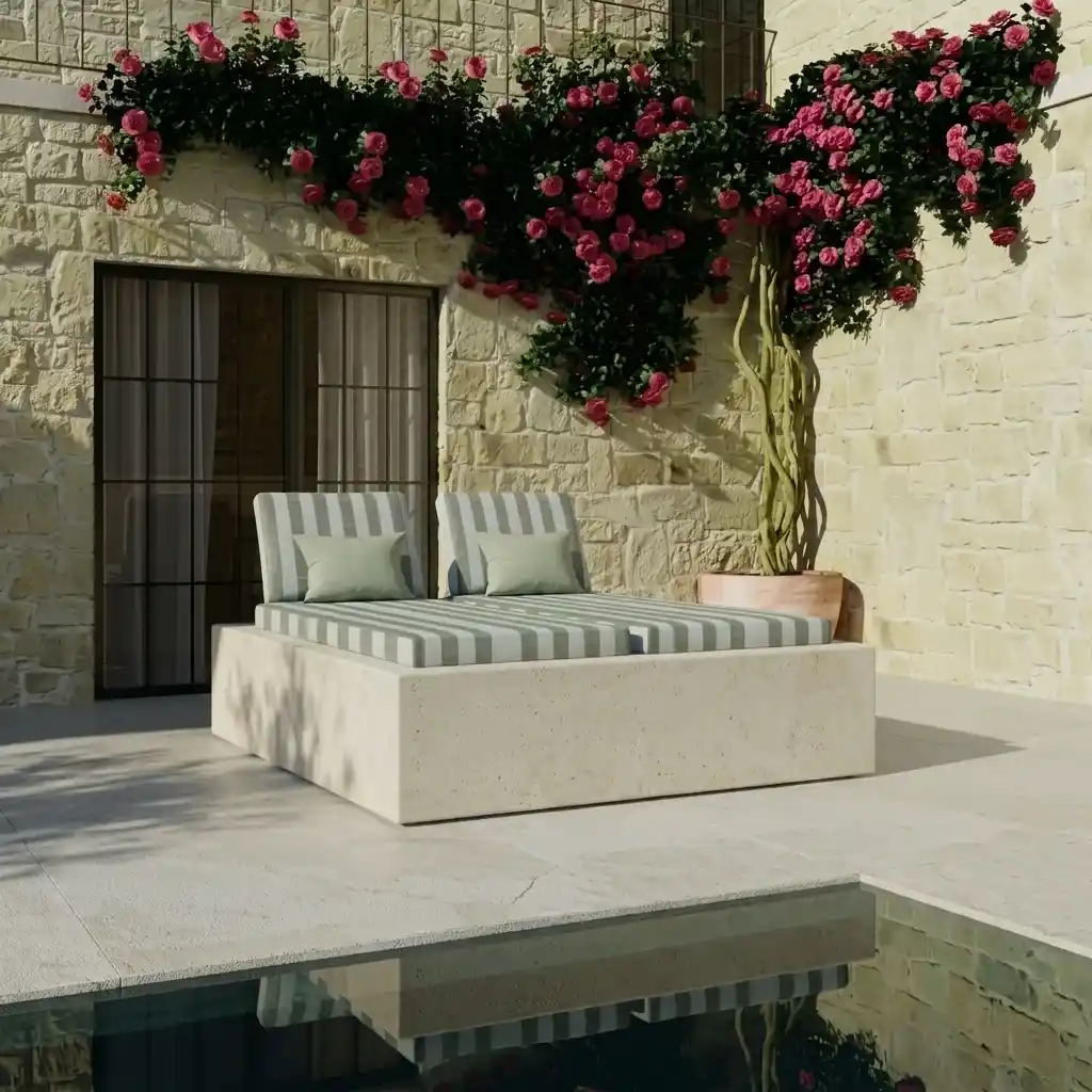 White outdoor daybed with striped cushions beside a pool, against a stone wall with red bougainvillea