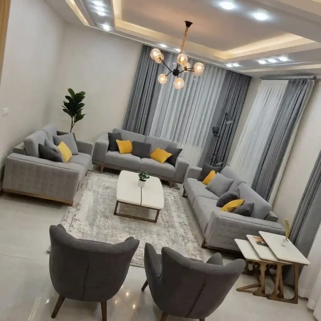 Custom cushions in a modern Dubai living room with gray sofa and yellow accent cushions