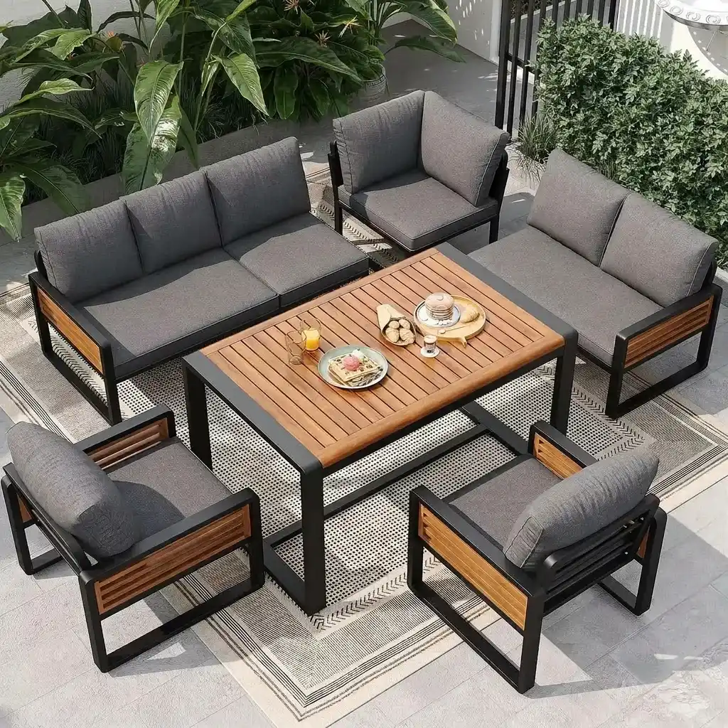 Modern outdoor seating set with grey fabric cushions and wooden armrests around a slatted wooden coffee table